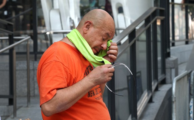 A person wipes his face outside Madison Square Garden during a heatwave in New York on July 1, 2026. Tens of millions of Americans sweltered under furnace-like temperatures this week as central and eastern cities hunkered down for a heat wave set to last through the July 4 holiday weekend. Dozens of local temperature records could be broken, the National Weather Service (NWS) warned, with temperatures in many places to surpass 100 degrees Fahrenheit (38 degrees Celsius) and high humidity pushing the heat index as high as 115 degrees. (Photo by TIMOTHY A. CLARY / AFP via Getty Images)