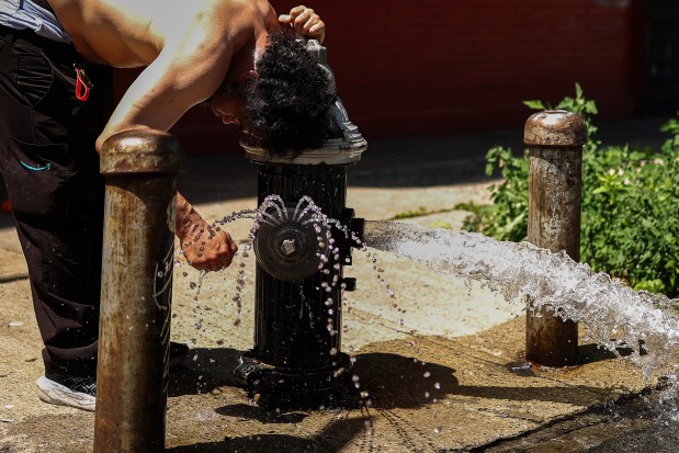 A man cools off at a fire hydrant in the Hamilton Heights neighborhood in the Manhattan borough of New York City on July 2, 2026. 