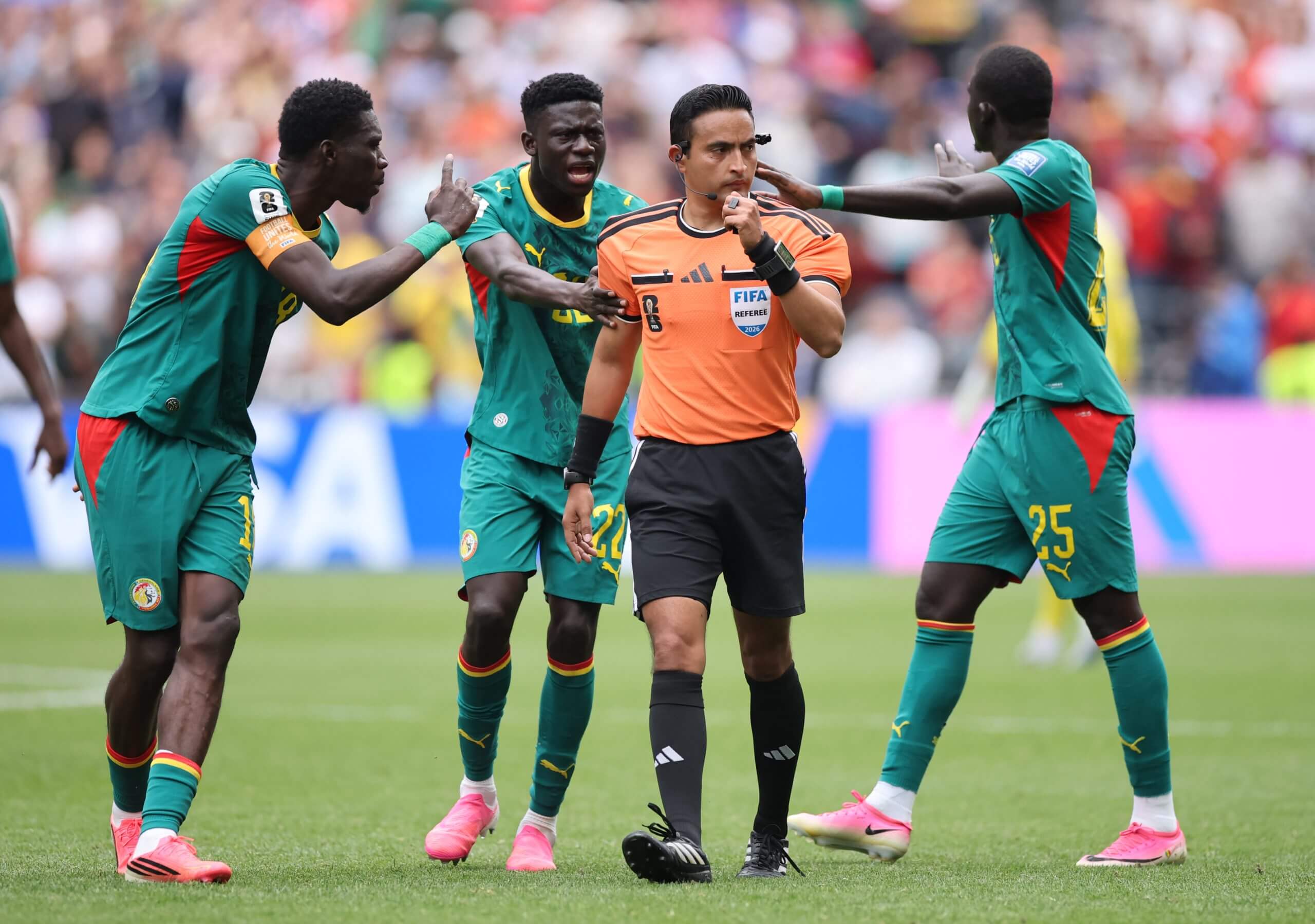 Senegal's players protest the award of Belgium's late penalty