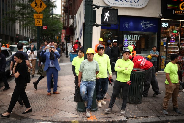 People and workers evacuated from nearby buildings due to structural damage look on in the Manhattan borough of New York City on July 7, 2026. Emergency services evacuated a busy Manhattan street block during the Tuesday morning rush hour of July 7, after structural columns buckled inside a skyscraper undergoing construction work, according to firefighters. (Photo by CHARLY TRIBALLEAU / AFP via Getty Images)