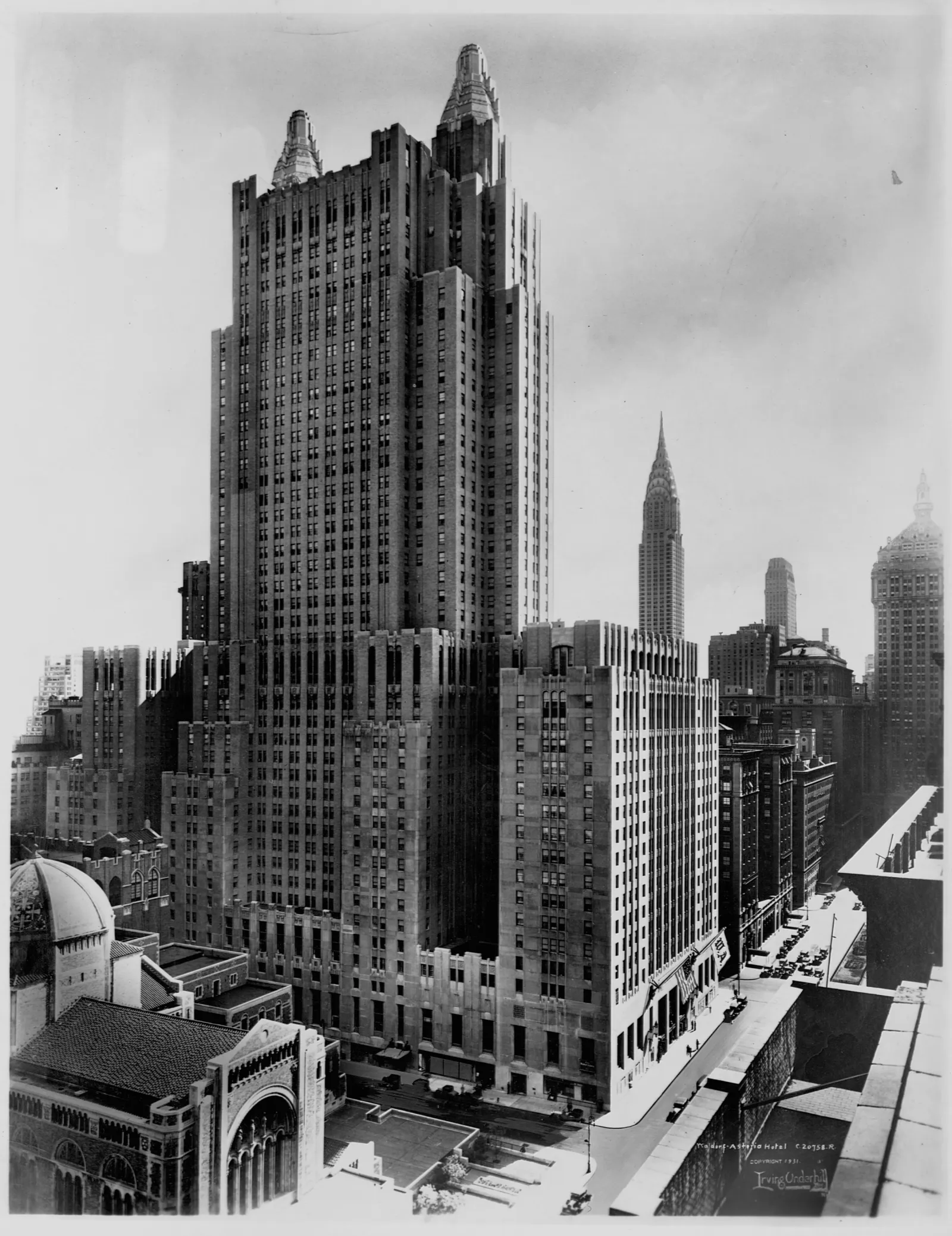 A view of the Waldorf-Astoria hotel with St. Bartholomew's Church in the foreground, captured around 1930.