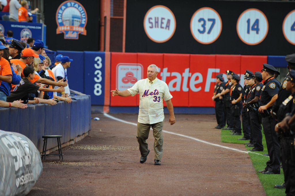 A man in a "Mets 33" jersey waving at fans in the stands at Shea Stadium.