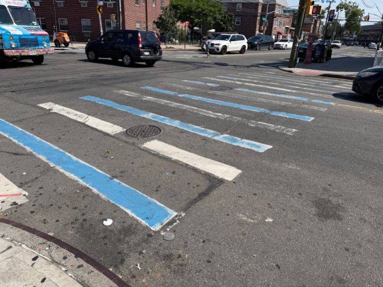 A crosswalk is painted in the colours of Argentina in Queens, NY