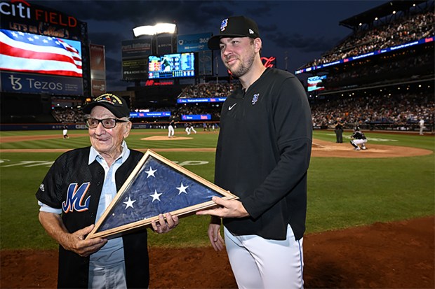 Joseph Finamore, left, was honored at a 2022 Mets game, and was given a flag by pitcher Tyler McGill. (New York Mets / MLB)