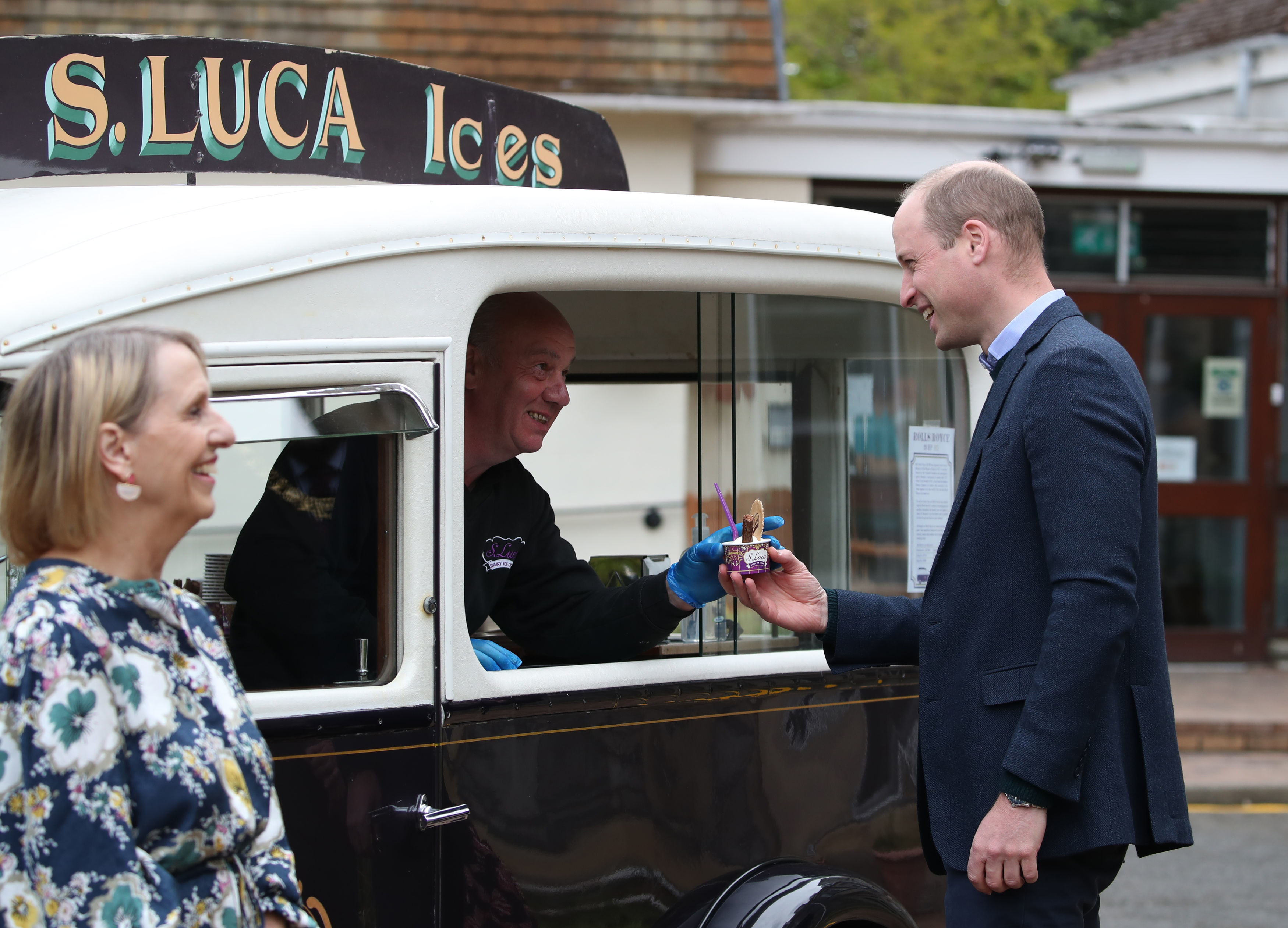 Prince William is handed a tub of ice cream during a visit to the Queens Bay Lodge Care Home in 2021