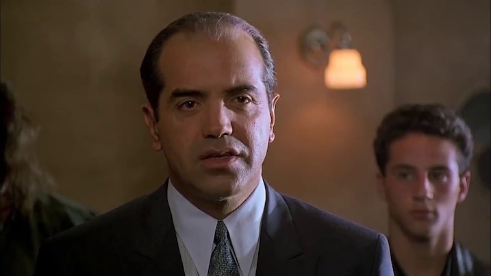Chazz Palminteri as Sonny addresses the room while Calogero watches in the background in A Bronx Tale.