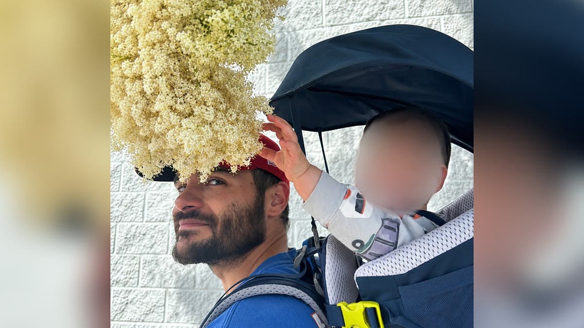 image shows man with small child on his back