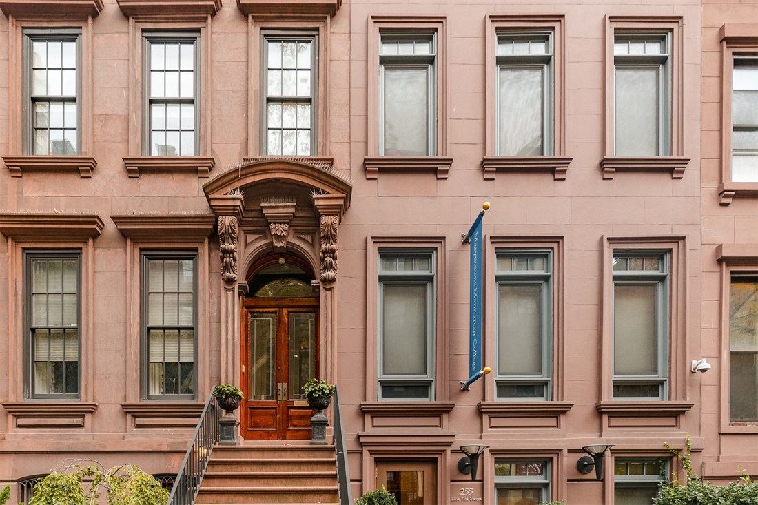 A brownstone building on a New York City street.