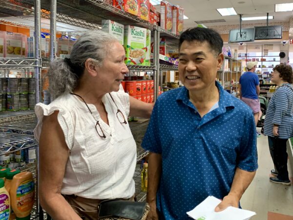 Fellow small business owner Estela Johannesen says goodbye to All in One Deli Mart owner Minki Lee. Johannesen owns James Weir Florist on Montague Street. Photo: Mary Frost/Brooklyn Eagle