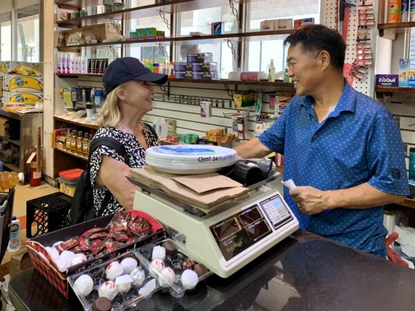 Neighbor Debbie Prince shakes the hand of All in One Deli Mart owner Minki Lee. Photo: Mary Frost/Brooklyn Eagle