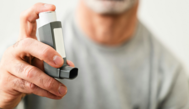 close up of a man's hand holding an inhaler used for asthma medication