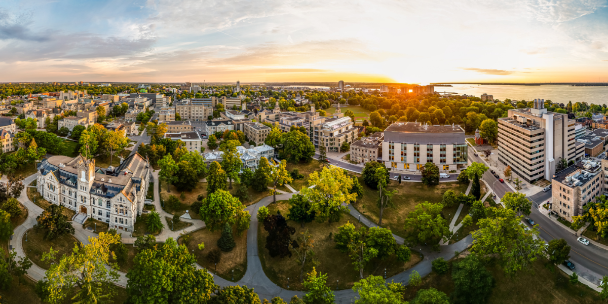 aerial panoramic view of Queen's campus with a golden hour sunset