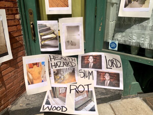 Tenants display posters showing some of the conditions at the Riverside Houses, including a radiator falling through the floor, mite bites and dangerous stairs. Photo: Mary Frost/Brooklyn Eagle