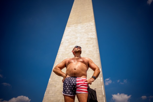 Josh Simon of Arlington, Virginia wears American flag patterned shorts as he stands in front of the base of the Washington Monument on the National Mall as the nation celebrates America's 250th anniversary on July 03, 2026, in Washington, DC. Many Fourth of July festivities have been shortened and some are facing cancellations amid an extreme, multi-day heat wave bringing dangerous triple digit temperatures to much of the eastern United States. (Photo by Andrew Harnik/Getty Images)