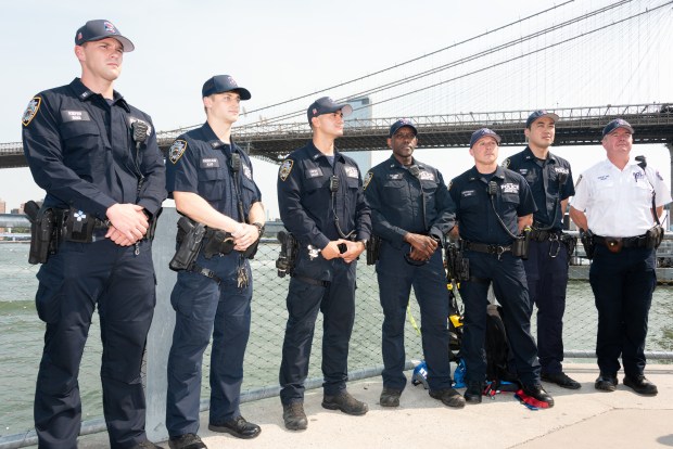 Officer Christian Yepes and Det. Eric Miller (center) of the NYPD's Emergency Service Unit are pictured in Brooklyn on July 14, 2026. Yepes and Miller helped rescue a distraught woman from the Brooklyn Bridge on July 8. (Gardiner Anderson / New York Daily News)