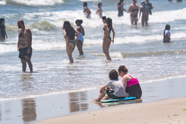 With a heat wave washing over New York City people took to the Beach in Far Rockaway at 59th Street in Queens on Thursday July 2, 2026. 1317, where, according to Lifeguards, no one was given permission to enter the water (but they still did) due to an adult shark along with a calf, being spotted in the area by FDNY Drone Patrol. An overhead photo showing the massive adult shark with the calf swimming on the left side was shown to a Daily News Photographer. (Theodore Parisienne / New York Daily News)
