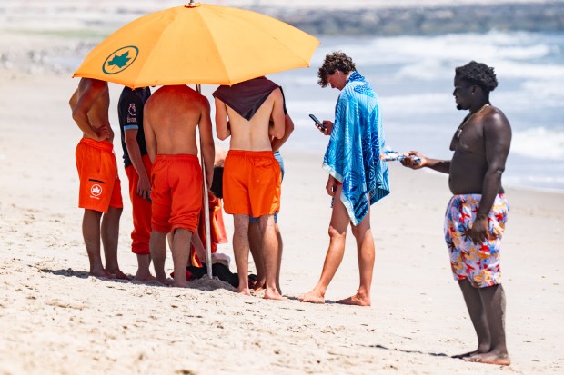 (Lifeguards hold court after shark sighhting) With a heat wave washing over New York City people took to the Beach in Far Rockaway at 59th Street in Queens on Thursday July 2, 2026. 1317, where, according to Lifeguards, no one was given permission to enter the water (but they still did) due to an adult shark along with a calf, being spotted in the area by FDNY Drone Patrol. An overhead photo showing the massive adult shark with the calf swimming on the left side was shown to a Daily News Photographer. (Theodore Parisienne / New York Daily News)