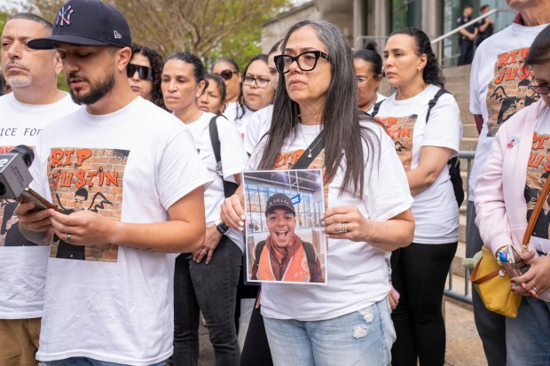 Toni Federico Diaz, mother of Justin Diaz, holds a photo of her son outside Queens Criminal Court, alongside other family members, on Friday, May 2, 2025. (Theodore Parisienne / New York Daily News)