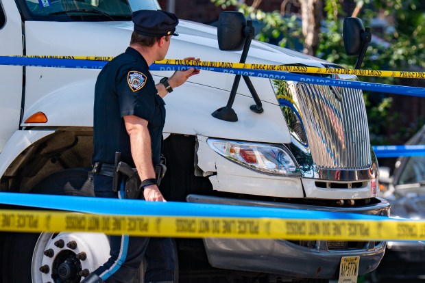Police investigate a fatal crash involving a motorcycle and a truck on Roosevelt Ave. in Woodside on Thursday morning. (Theodore Parisienne / New York Daily News)