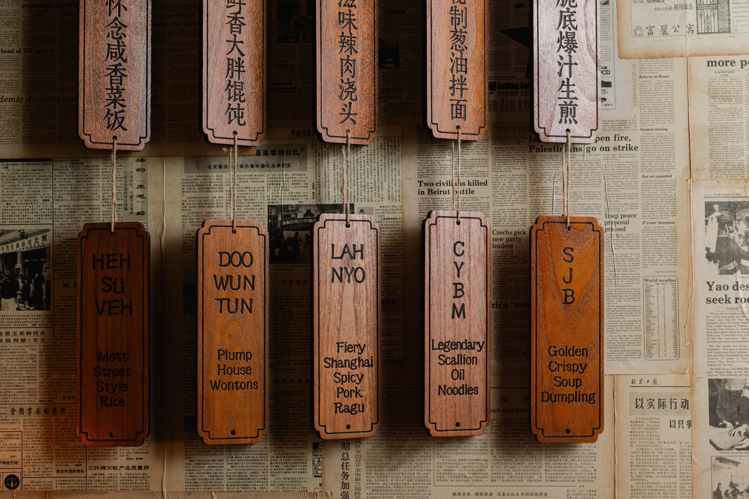 Hanging wooden tags with food items written on them.