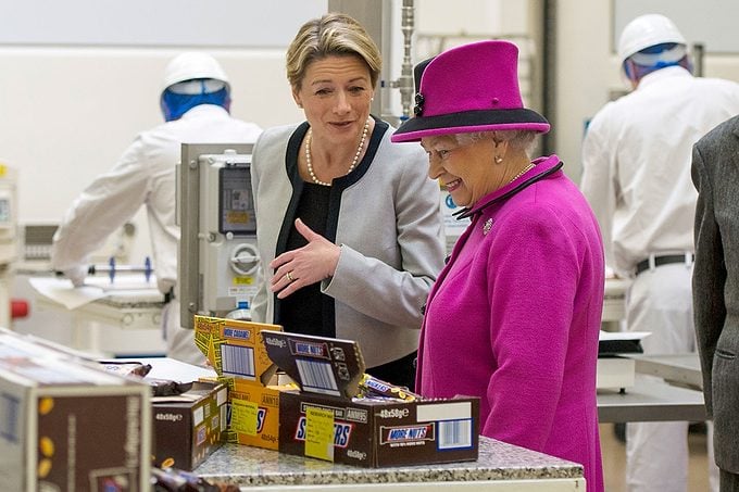 Britain's Queen Elizabeth II (CR) accompanied by Prince Philip, Duke of Edinburgh (2R), are shown chocolate products by Fiona Dawson