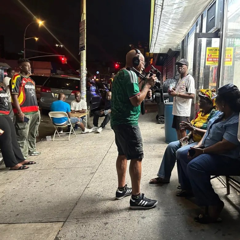 Victor Sanchez interviews neighbors outside Sanbra Door Restaurant on East Tremont Avenue in the Bronx during the halftime break in Ghana’s game Friday against Colombia. Credit: Ambar Castillo / Epicenter NYC