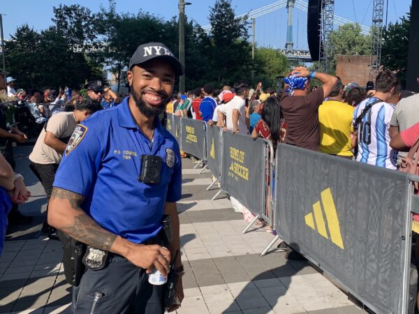 The 84th Precinct’s Police Officer Wallace Council handles crowd management and enjoys the game on Sunday. Photo: Mary Frost/Brooklyn Eagle
