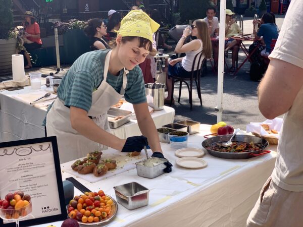 A chef from L'Appartement 4F spoons caviar onto little hot dogs to celebrate Bastille Day on Montague Street. Photo: Mary Frost/Brooklyn Eagle