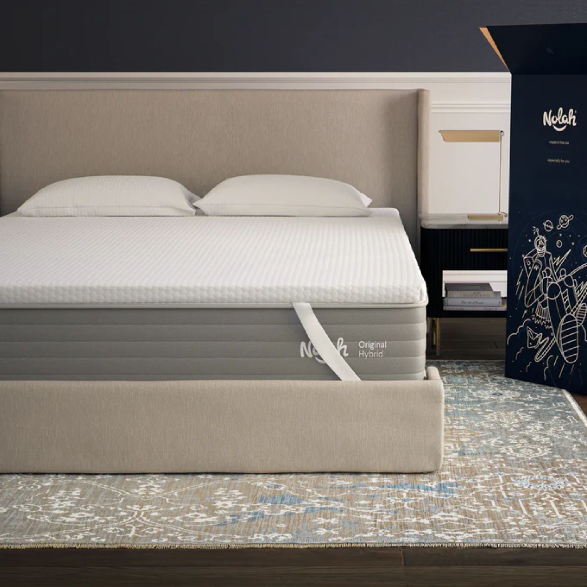 A white Nolah AirFoam&reg; Luxe Mattress Topper on a beige bed with beige headboard, on a Persian-style rug.