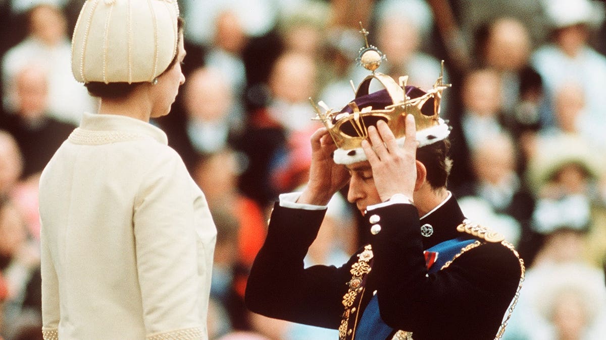 Prince Charles kneels before Queen Elizabeth at Caernarvon Castle.