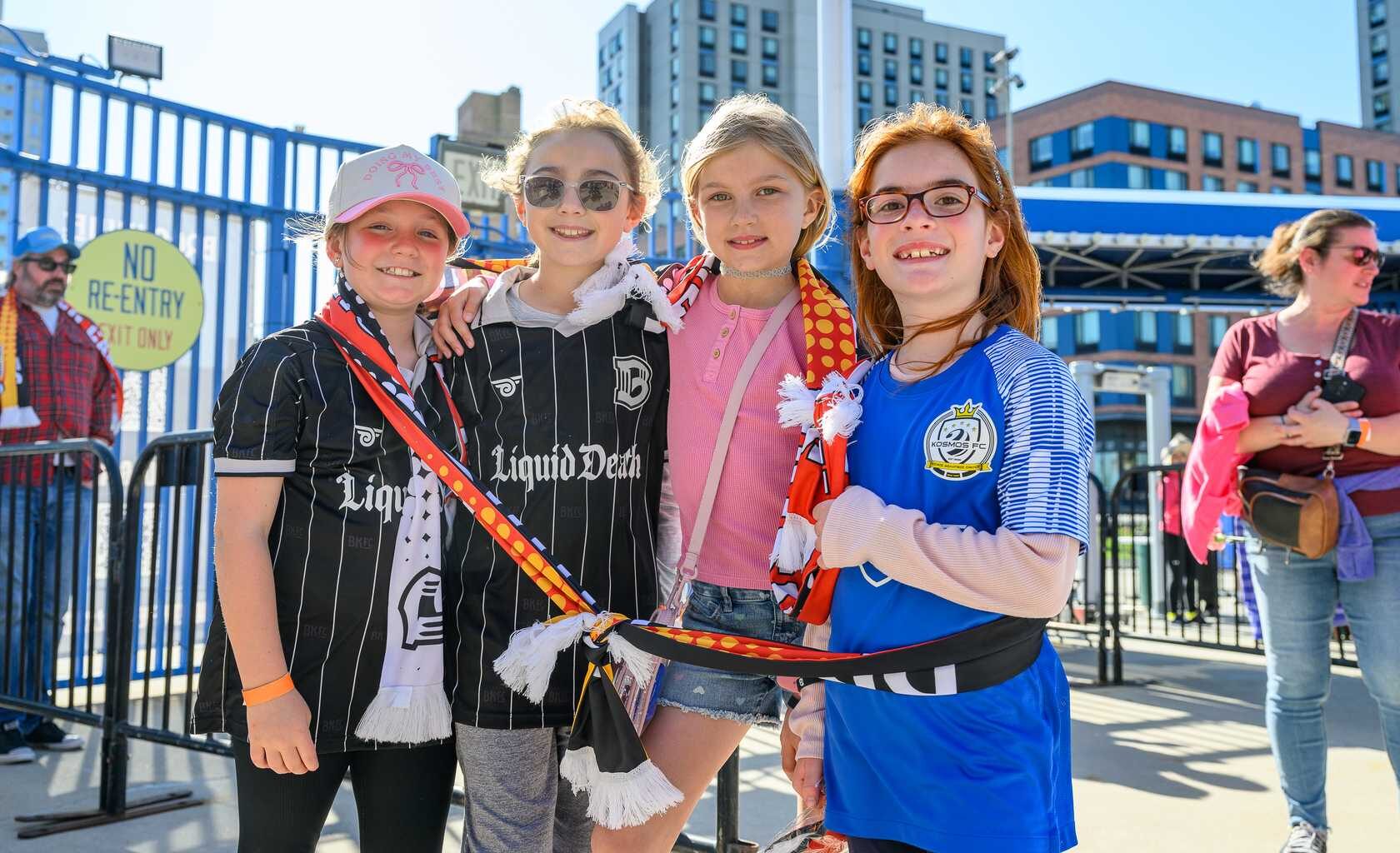 Young fans at a Brooklyn FC match cheering for their team