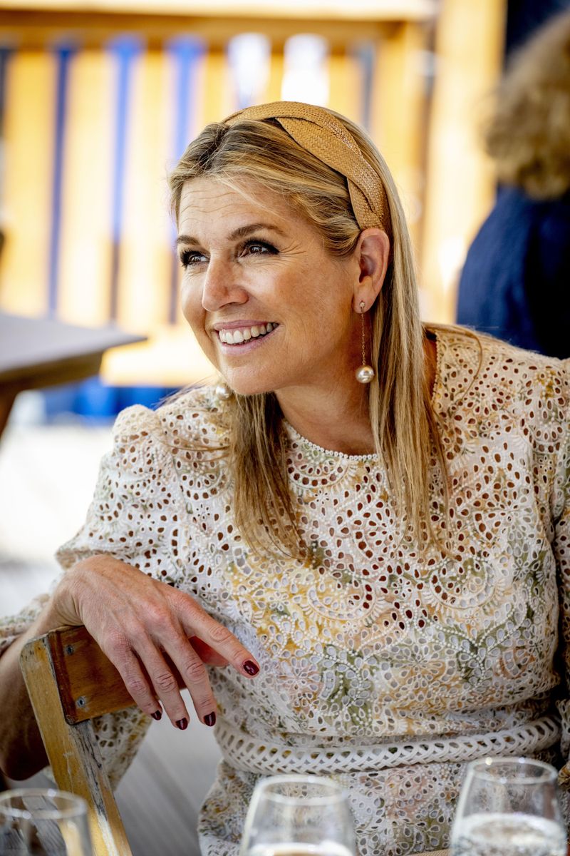 The Dutch queen paired her elegant summer dress with a woven camel headband, pearl drop earrings, and a neutral clutch.