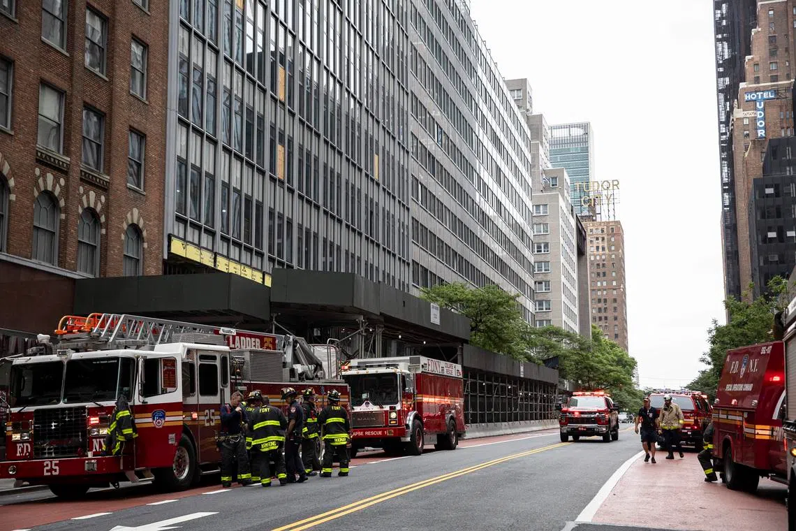 Firefighters gather outside of the former Pfizer headquarters on East 42nd Street near Grand Central Terminal, in New York, on July 7.
