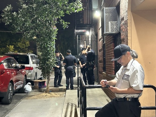 Police guard the entrance to the backyard of 593 Oak Terrace in the Bronx Friday evening after a 1-year-old boy fell five stories from a window there but survived. (Kerry Burke / New York Daily News)