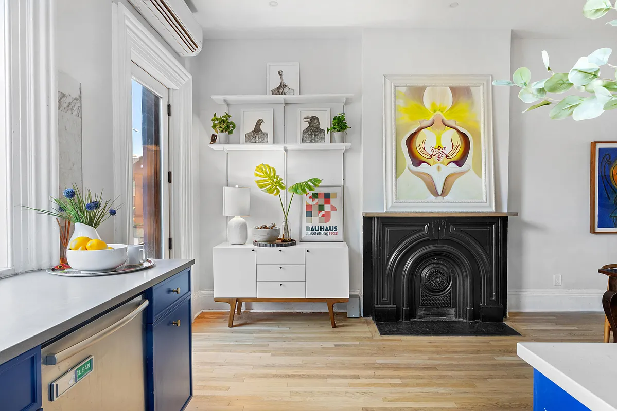 blue kitchen cabinets and a black mantel in the dining area