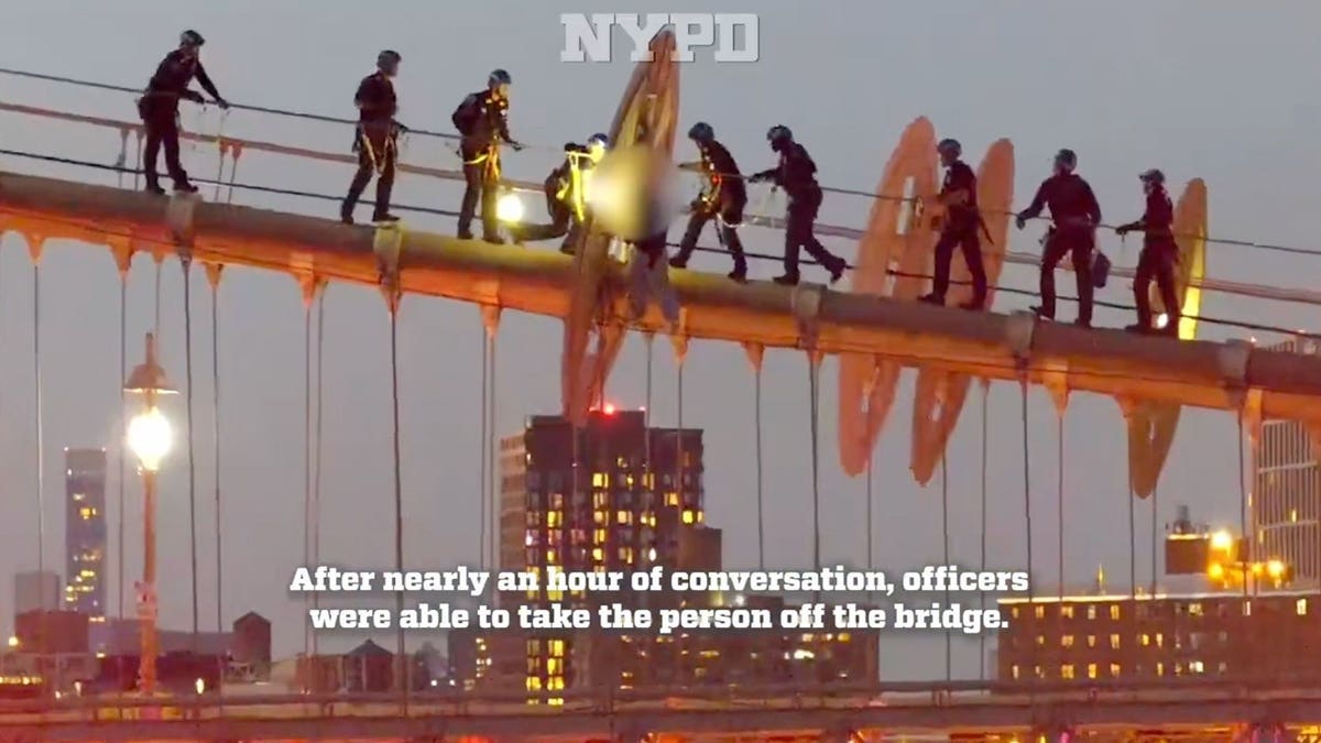 Body camera footage shows NYPD officers rescuing a woman from atop the steel cables of the Brooklyn Bridge.