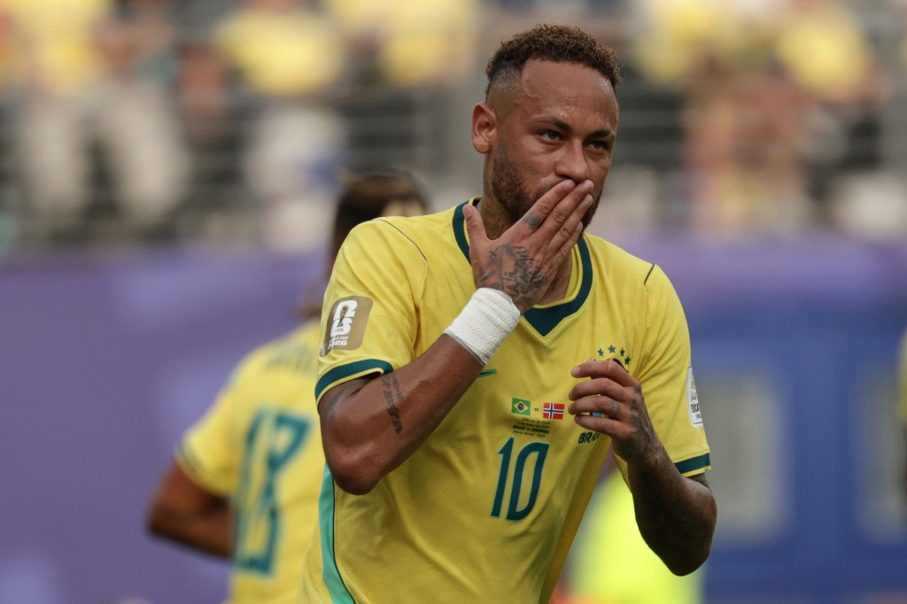 Neymar celebrates after scoring from a penalty kick in a soccer match between Brazil and Norway.
