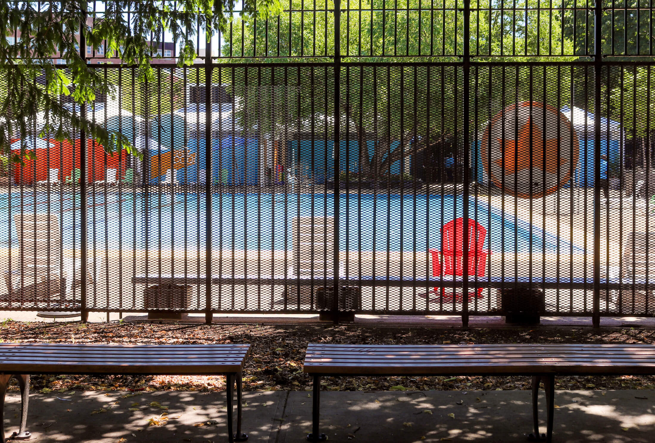 a view through the fence surrounding commodore barry pool