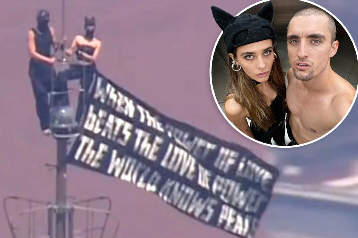 Kissing daredevils scale Empire State Building antenna, hanging flag 1,454 feet over NYC with cringe message