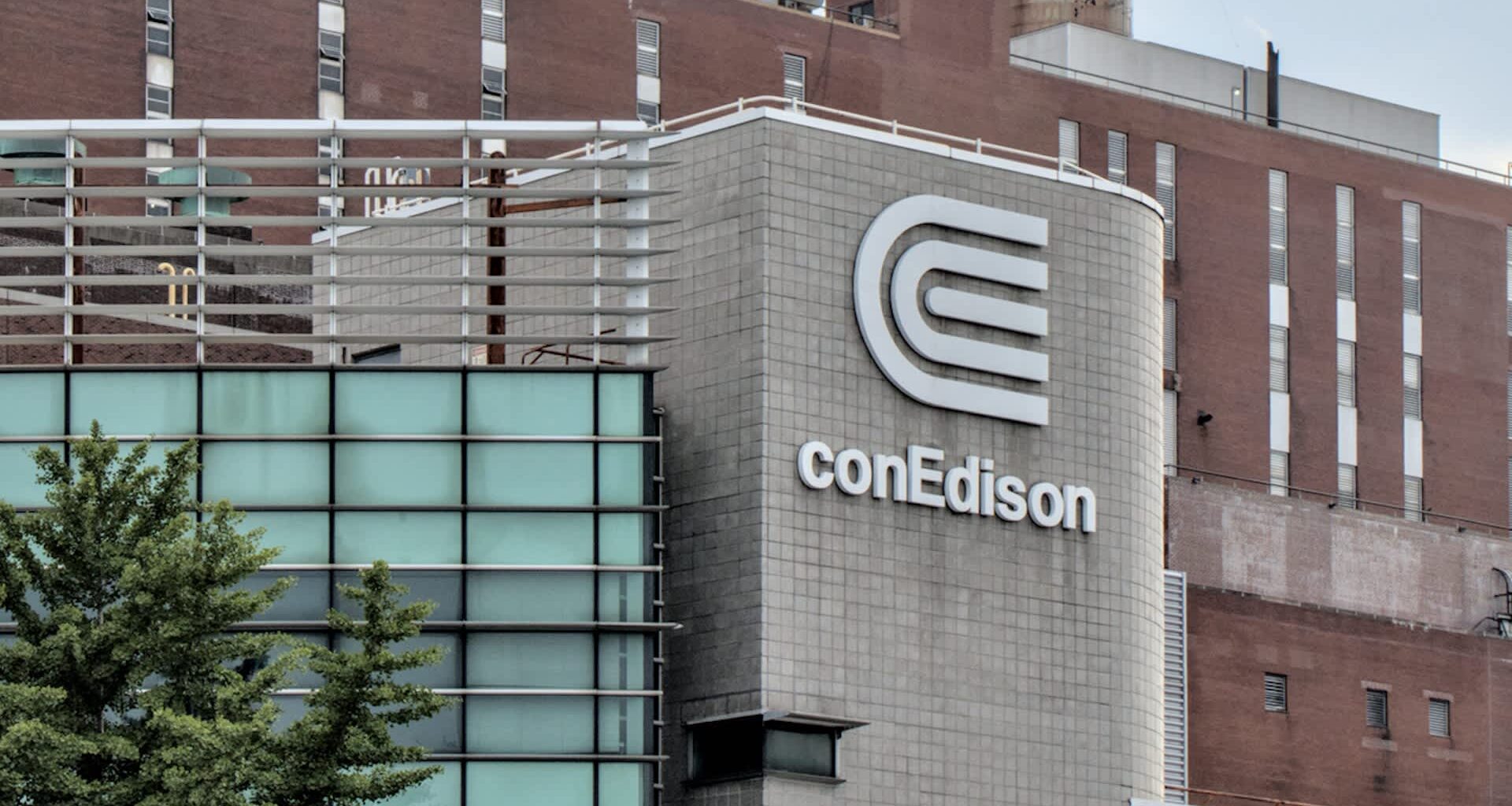 A conEdison building with modern architecture featuring glass and a prominent logo on the facade.