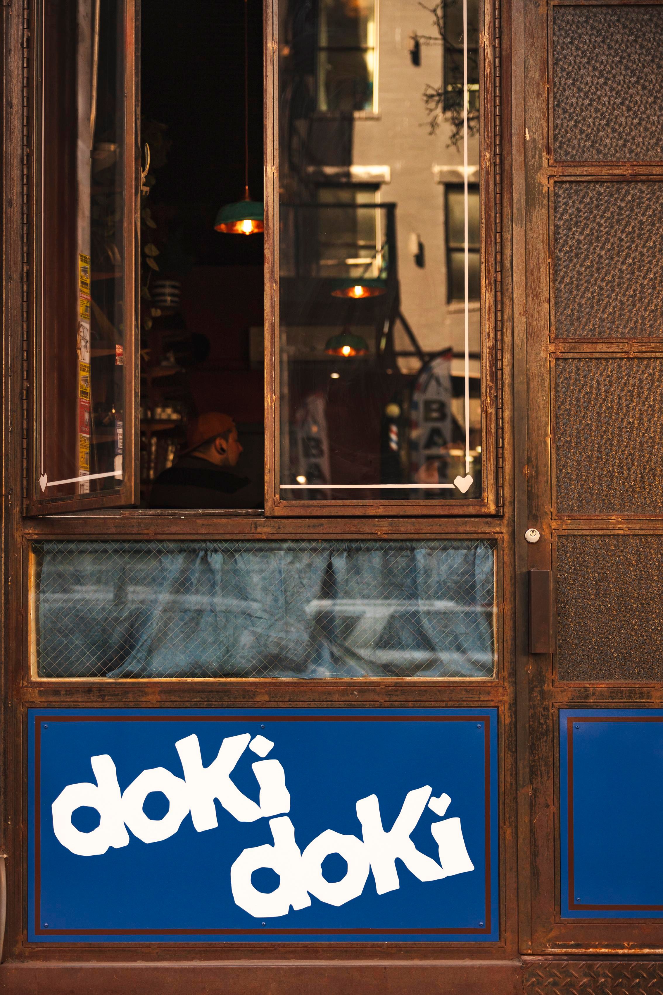 A bar facade with open windows and a sign below reading Doki Doki.