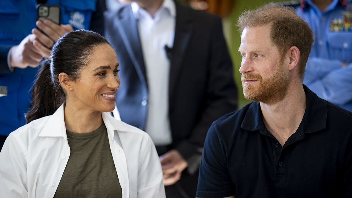 The Duke and Duchess of Sussex standing together at the QuestScope Youth Center in Za'atari refugee camp