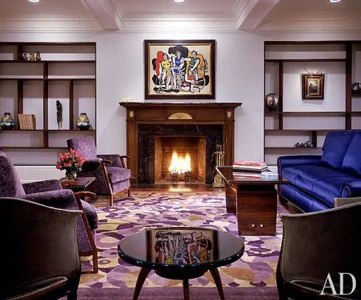 “I get strength from my art—all the paintings I own are powerful,” says Madonna. Les Deux Bicyclettes, 1944, by Fernand Léger hangs over the living room mantel. Le Coeur Voilé, 1932, by Dalí is framed by Mondrian-style bookshelves designed by Ciccone. The Art Deco pieces—a Macassar ebony low table by Jean Pascaud by the sofa, the armchairs at left by Eugène Printz, two walnut bergères en gondole, foreground, by Armand Albert Rateau and the circular lacquered table by Dominique—are all anchored by the circa-1930 rug, initialed “CR.” Sofa fabric is from Clarence House.