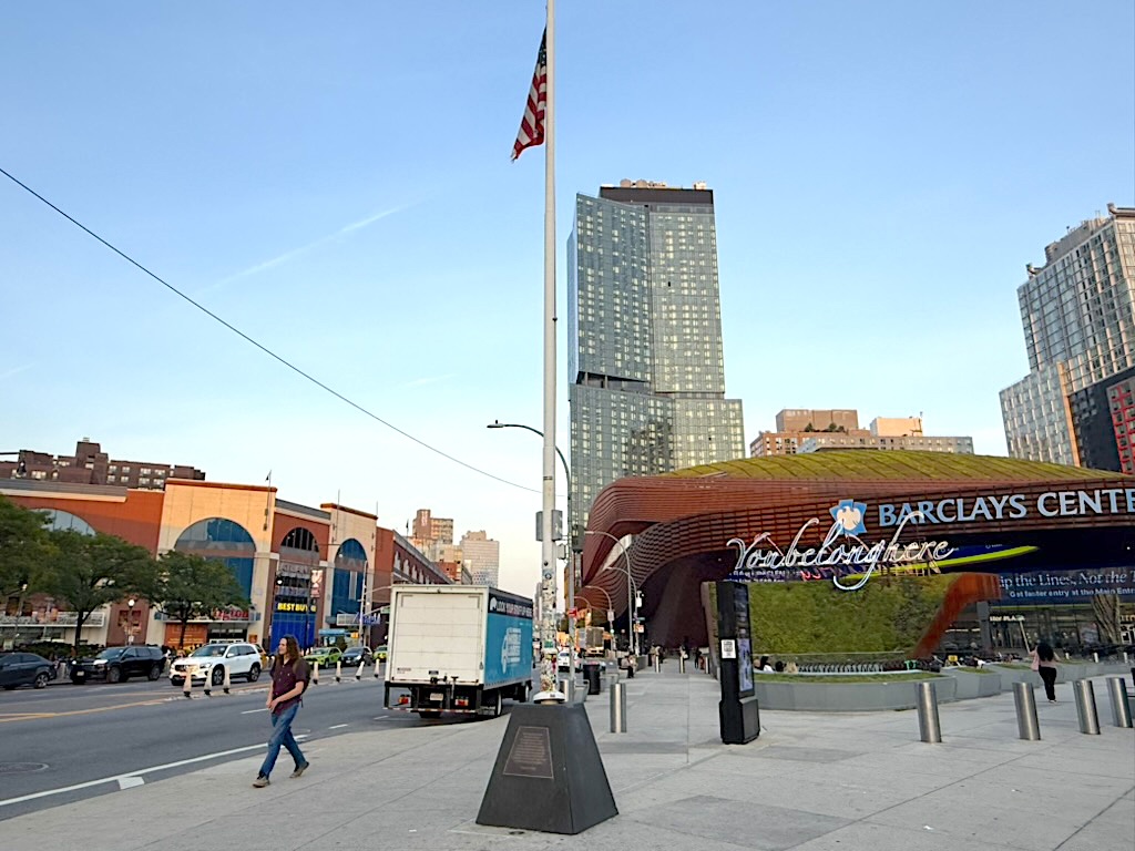 Street view of Barclays Center, showcasing the modern architecture and surrounding buildings in an urban setting.