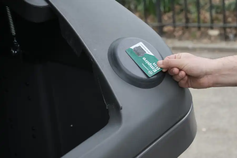 card being held against trash container