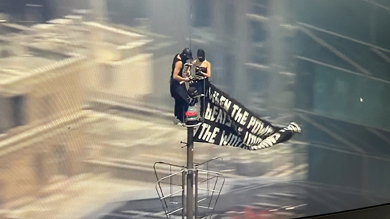 Two people scale Empire State Building in New York City