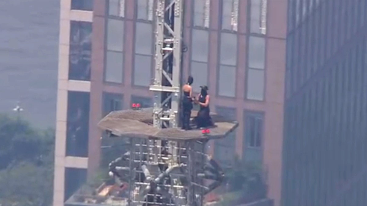 A person proposing on the Empire State Building spire.