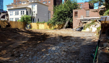 site of demolished house with a brick garage in process of being demolished