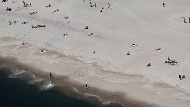 People sunbathe on Jones Beach in Long Island, New York on May 22, 2019.