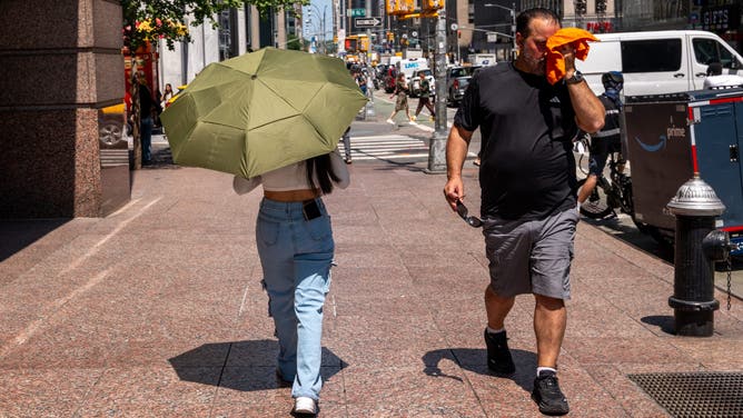 NEW YORK, NEW YORK - JULY 29: People try to stay cool on the sweltering streets of Manhattan as the region experiences another heatwave on July 29, 2025 in New York City. Temperatures are expected to reach into the high 90s with a heat index well above 100 degrees.